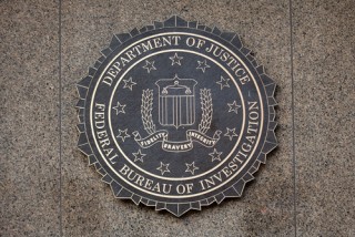 Image of DOJ logo via Mark van Scyoc/Shutterstock