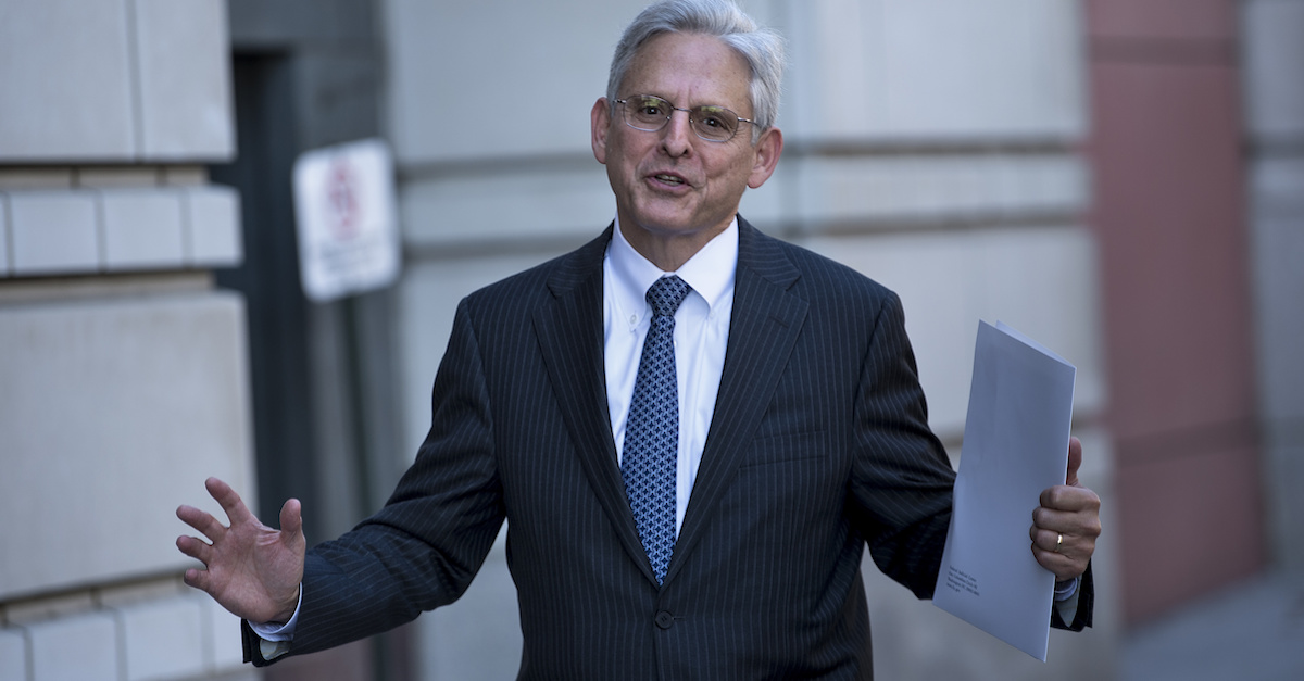 Merrick Garland holds a piece of paper while standing