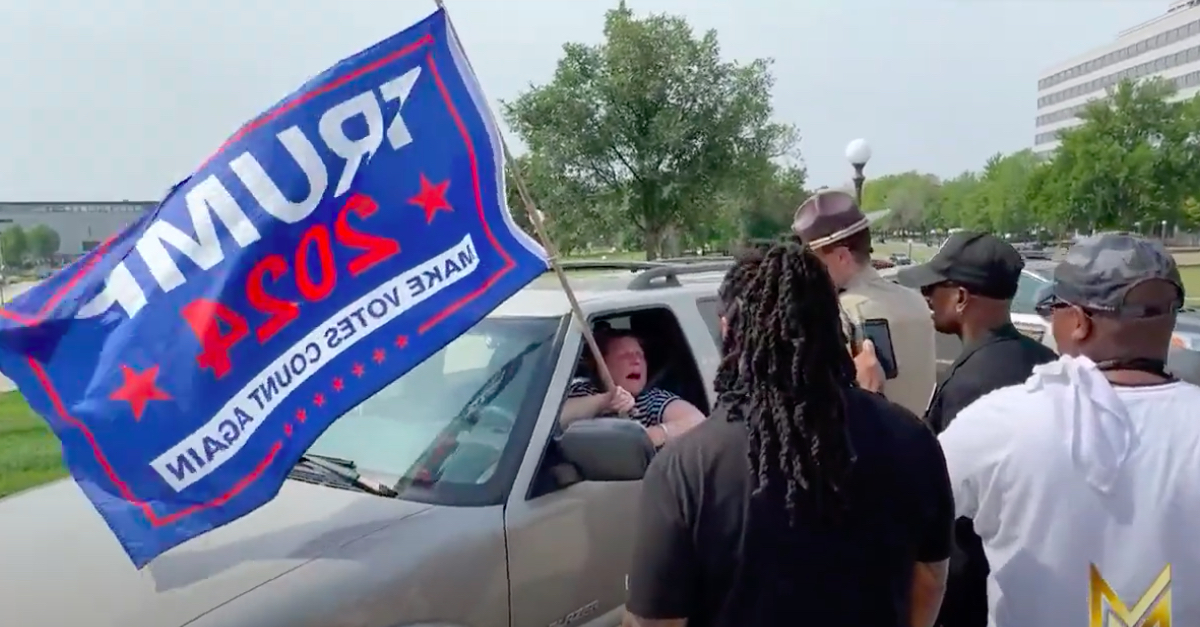 Tammy Jo Jekah waiving Trump 2024 flag after driving on Minn. Capitol lawn