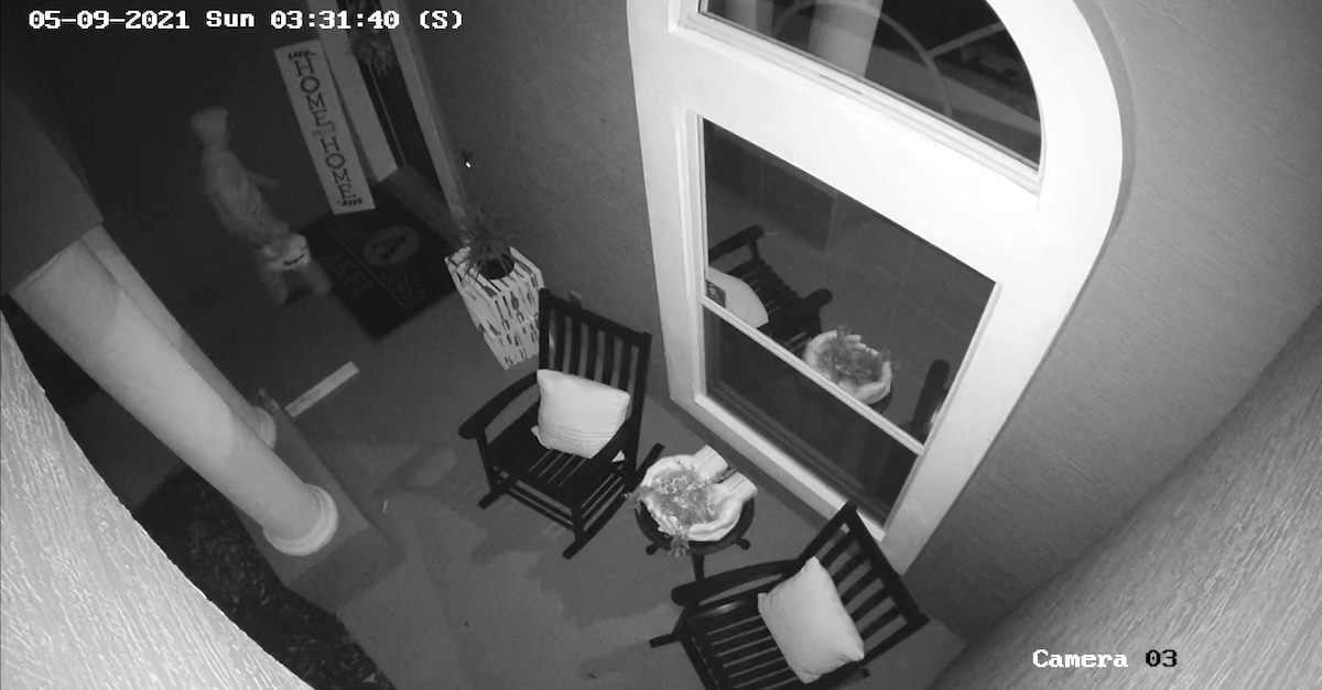 A still frame from a surveillance camera shows who prosecutors and law enforcement authorities believe to be alleged murderer Aiden Fucci approaching the front door of his home while carrying his shoes.