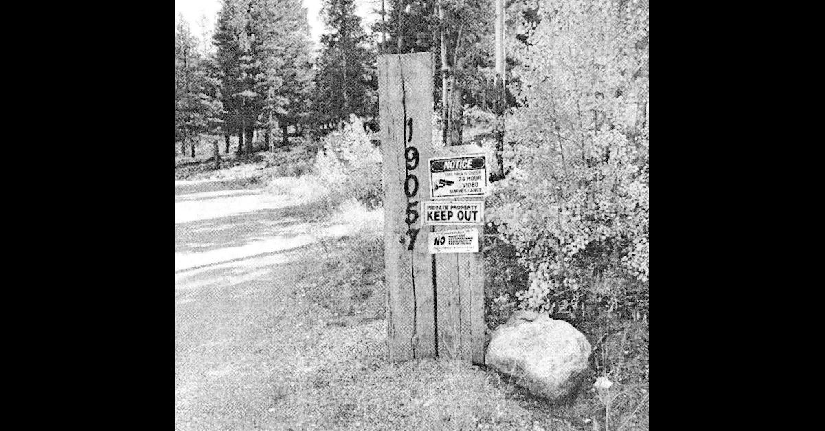 A photograph embedded within a Chaffee County, Colo. arrest affidavit shows "no trespassing" and electronic surveillance warning signs along the driveway to the home formerly owned by Barry Morphew.