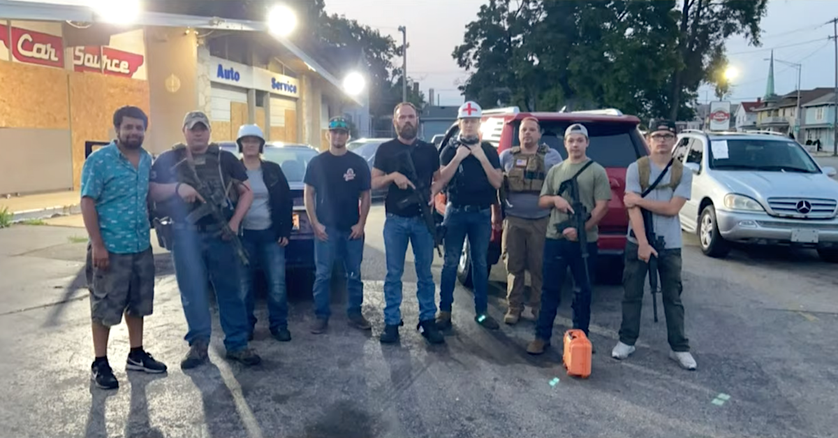 Sahil Khindri (far left) testified that he posed with Kyle Rittenhouse's posse but claimed he did not give them permission to guard his family's used car lot. Rittenhouse is at right in a green shirt standing behind an orange container on the ground. An individual identified as Nick Smith appears wearing a white had adorned with a red cross. (Evidence photo via the Law&Crime Network)