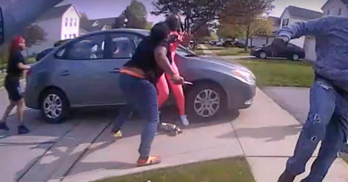 A still frame from Officer Nicholas Reardon's body camera video shows Ma'Khia Bryant (center, in black shirt and jeans) in the process of shoving a knife (visible in her right hand) toward Tionna Bonner (center, in pink). Officer Reardon opened fire split seconds later as Bryant's knife was near Bonner's head and neck. Bonner said she felt the blade against her skin.