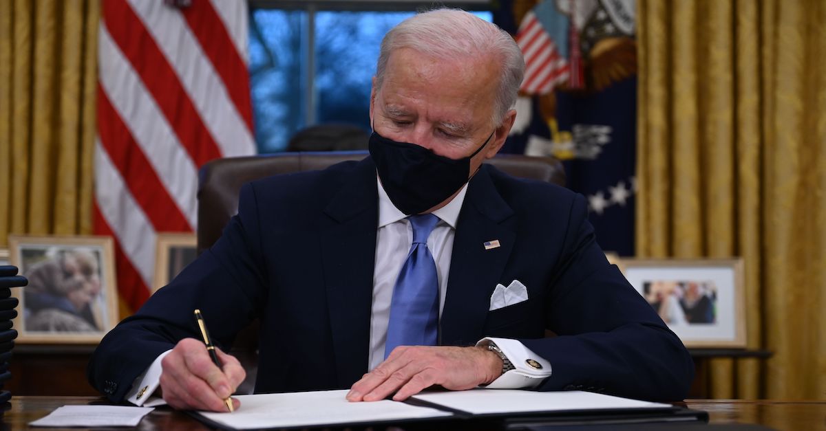 President Joe Biden is seen signing executive orders on his first day in office, Jan. 20, 2021.