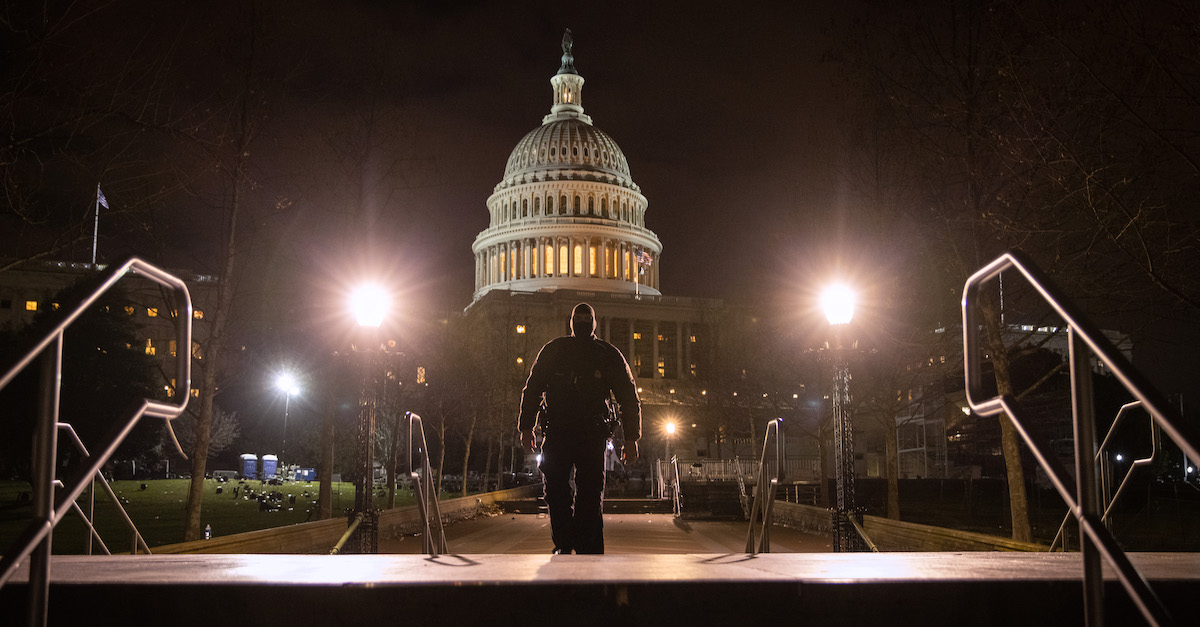 A Washington DC police officer walks through the grounds of the U.S. Capitol after nightfall on January 6, 2021. (Photo by John Moore/Getty Images)