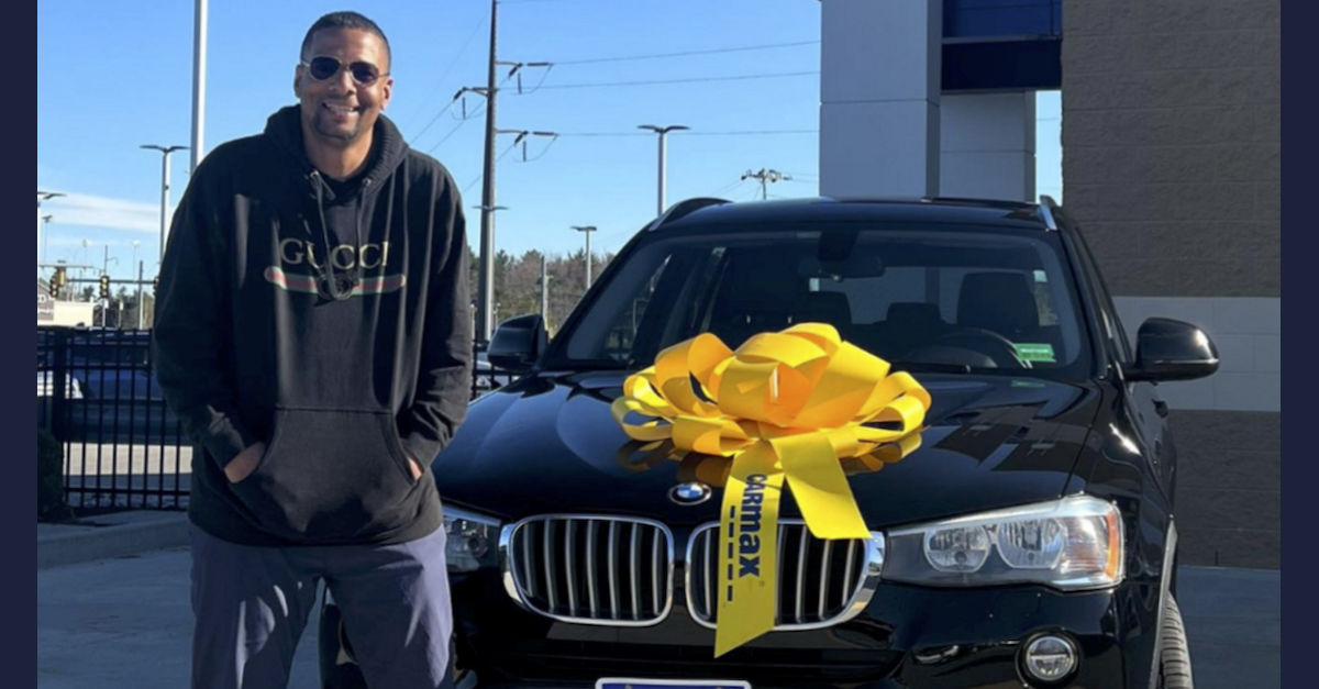 Raymond Lester appears in a photo posing in front of a black SUV