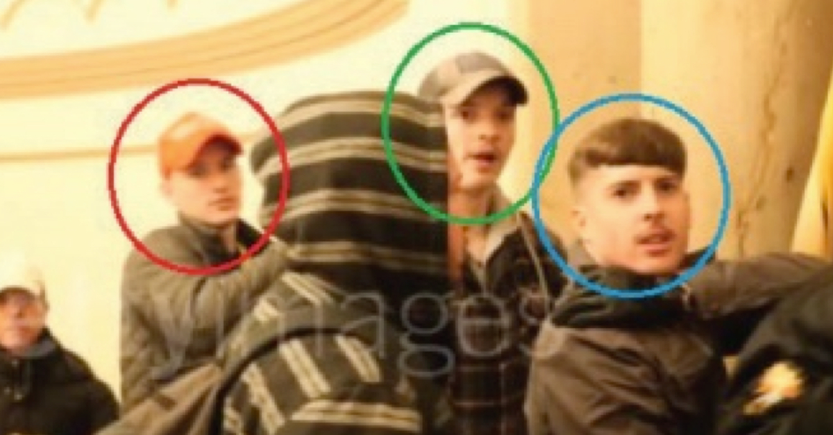 Micah Coomer is wearing a red baseball cap and dark jacket. Abate is in a dark baseball cap and dark jacket with a light collar. Hellonen has a bowl cut and what appears to be a thin mustache. They are looking in the direction of the camera.