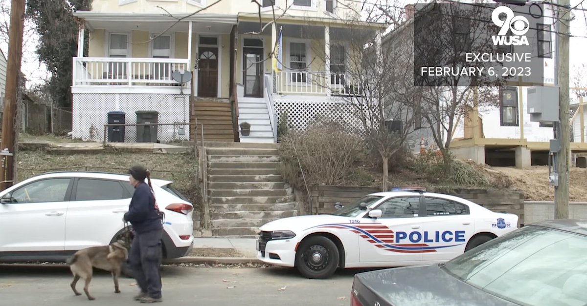 A K-9 officer walks past the D.C. home where a handyman was found decapitated.