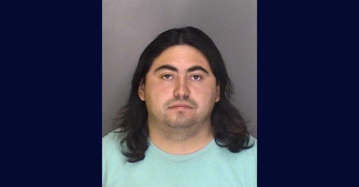 Booking photo of Mark Anthony Gonzales; he appears with medium length black hair and wears a light green tee shirt