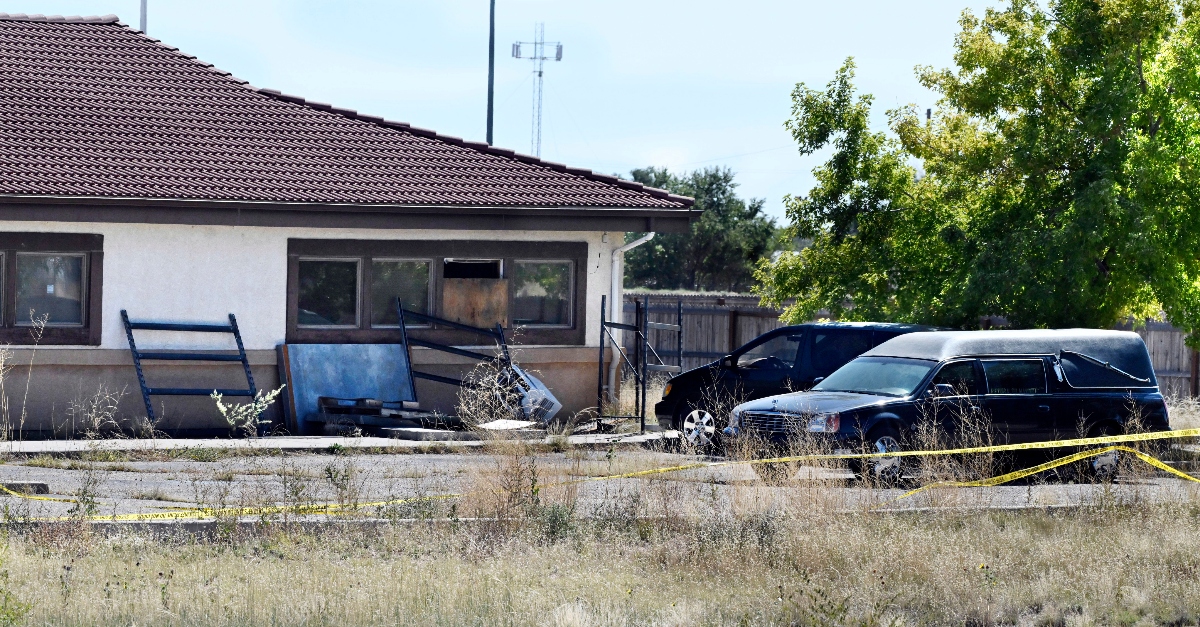 FILE - A hearse and debris can be seen at the rear of the Return to Nature Funeral Home in Penrose, Colo., Oct. 5, 2023. A family filed a lawsuit Monday, Oct. 30, against the Colorado funeral home where 189 decaying bodies were found alleging that the owners, a husband and wife, allowed the remains of their loved ones and to “rot” away while they sent families fake ashes. (Jerilee Bennett/The Gazette via AP, File)