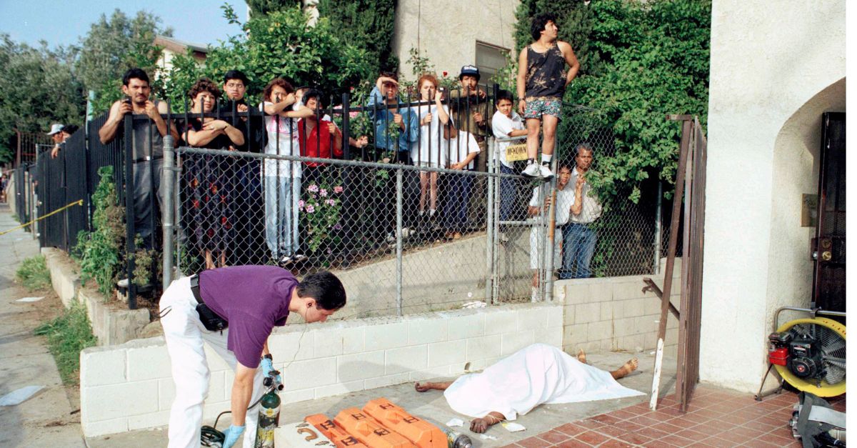 An emergency medical technician, who refused to identify himself, grabs supplies next to the body of a pregnant woman who was one of seven people who died in an apartment complex fire near downtown Los Angeles, May 3, 1993. (AP Photo/Doug Pizac)