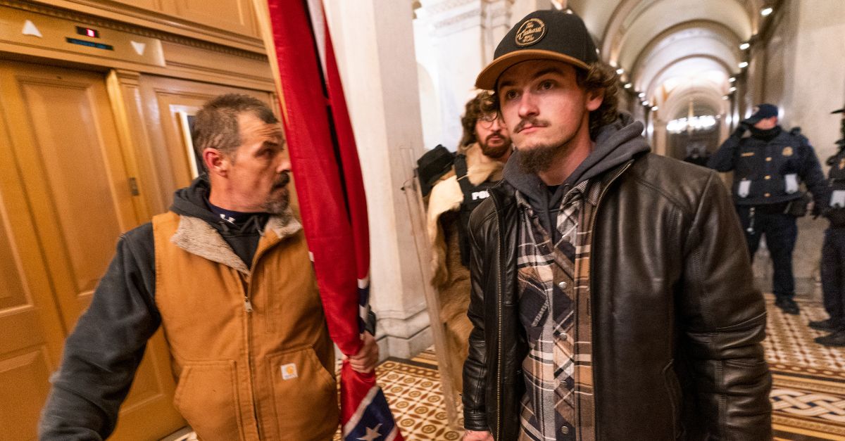 Kevin Seefried, left, carries a rolled up Confederate flag which he later paraded through the U.S. Capitol on Jan. 6, 2021. His son, right, Hunter Seefried requested immediate release from prison and a sentence reduction in February 2024. (AP Photo/Manuel Balce Ceneta, File)