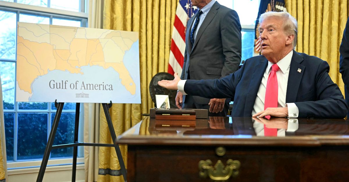 President Donald Trump gestures to a poster that says "Gulf of America" in the Oval Office at the White House in Washington, Tuesday, Feb. 25, 2025 (Pool via AP).