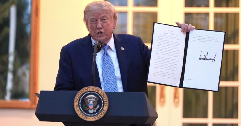 Donald Trump shows a signed order.
